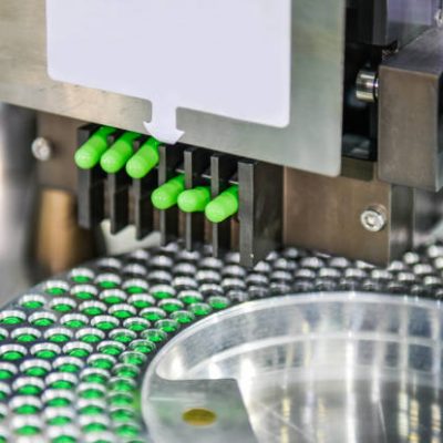 Green capsule medicine pill production line, Industrial pharmaceutical concept.